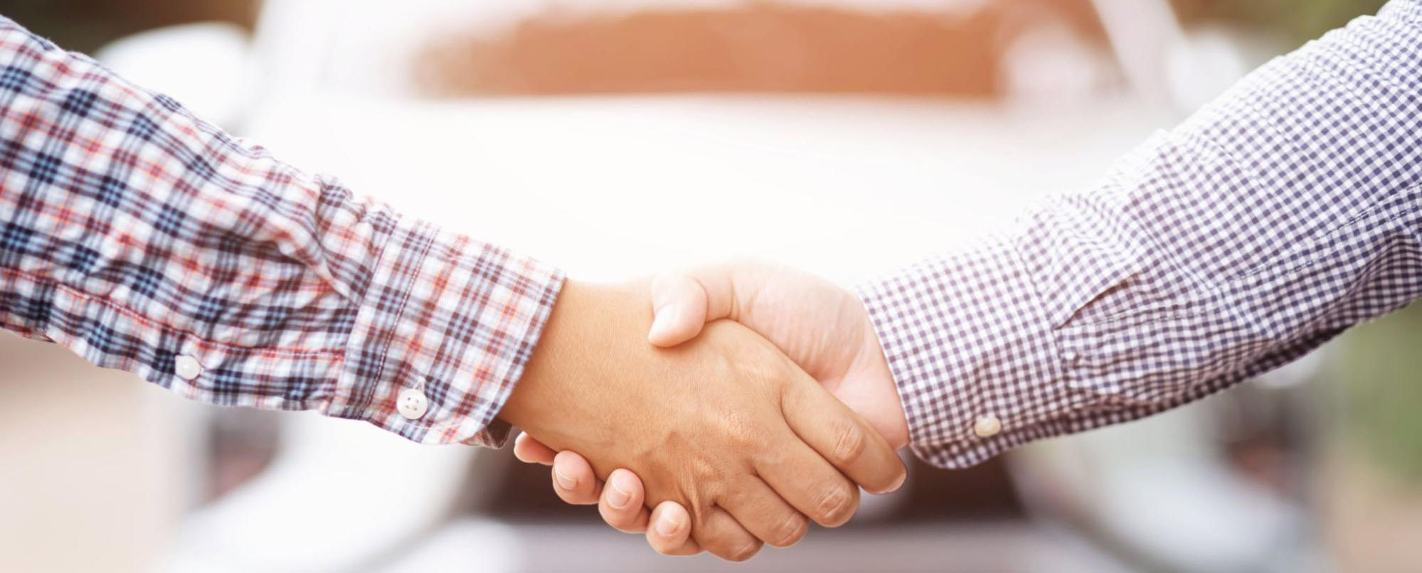 Car dealer shaking hands with client