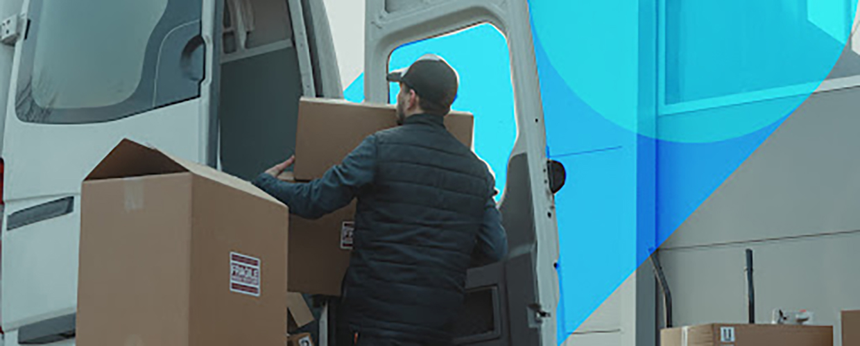 Delivery man placing packages in truck.