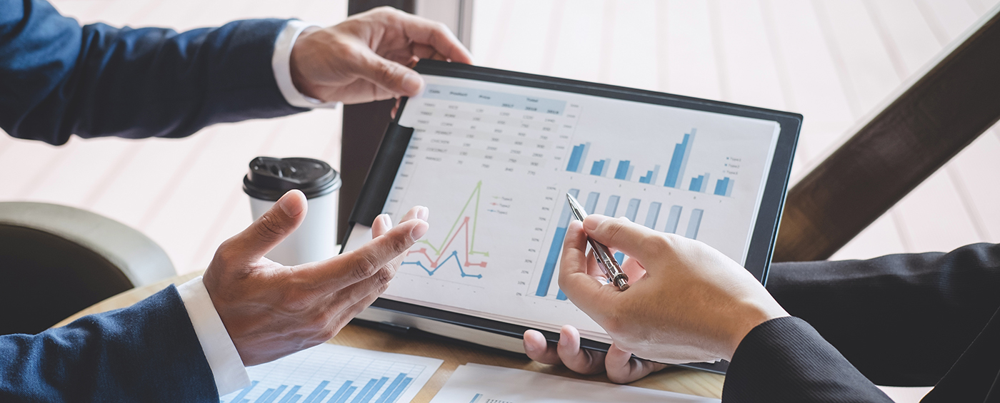 Two people reviewing business charts