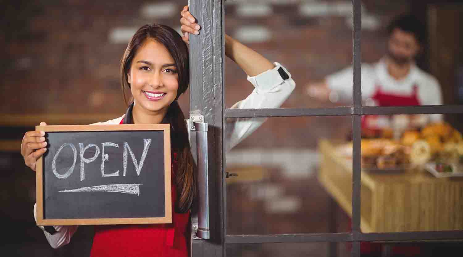 Business woman holding an open sign.