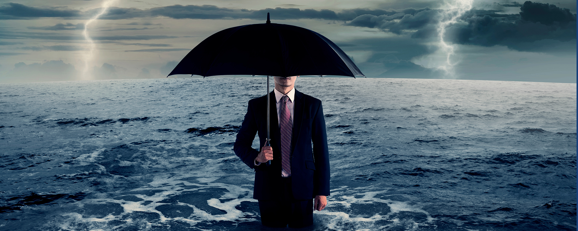 Business man holding umbrella during a storm.